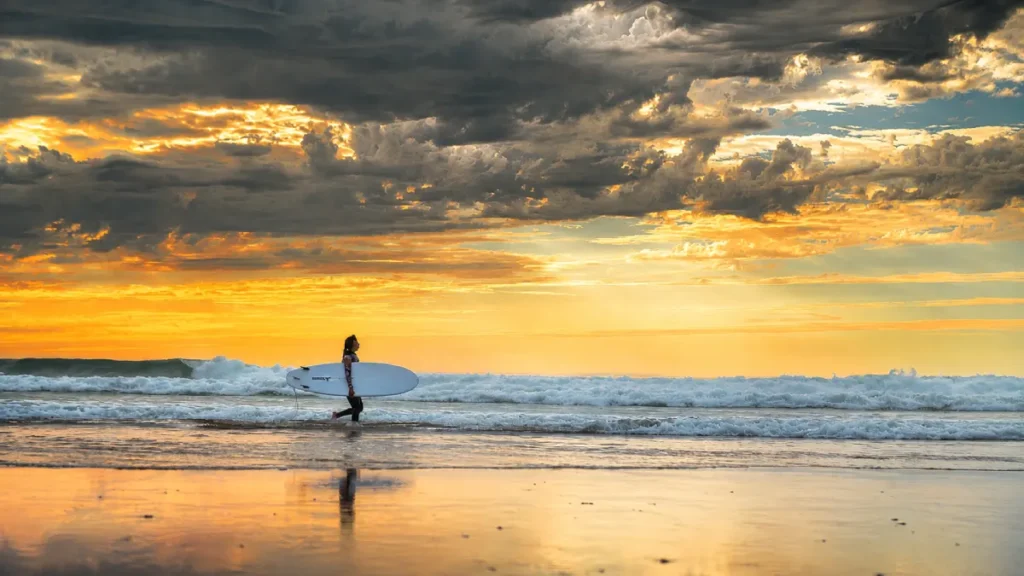 Surfer walking on Essaouira Beach with a surfboard