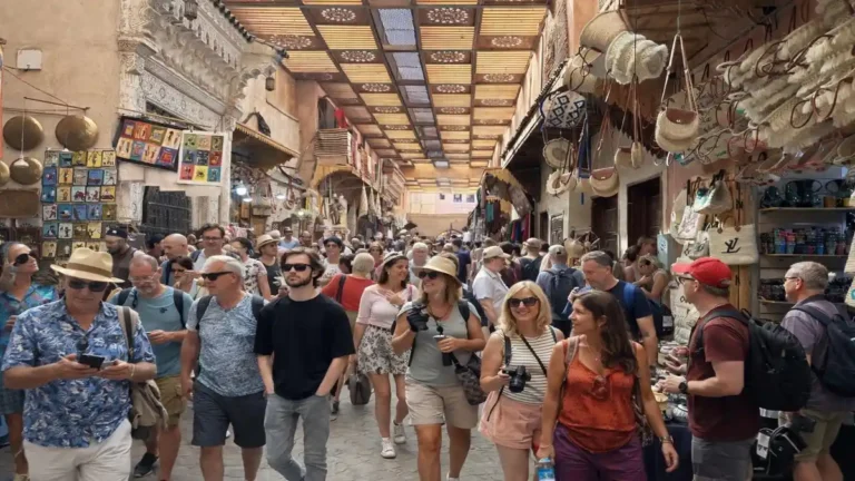 Busy Marrakech souks with tourists walking through the covered medina market