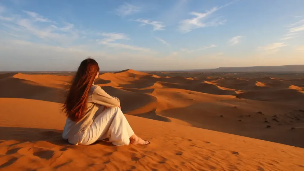 Solo traveler experiencing the Sahara Desert during a Morocco travel itinerary