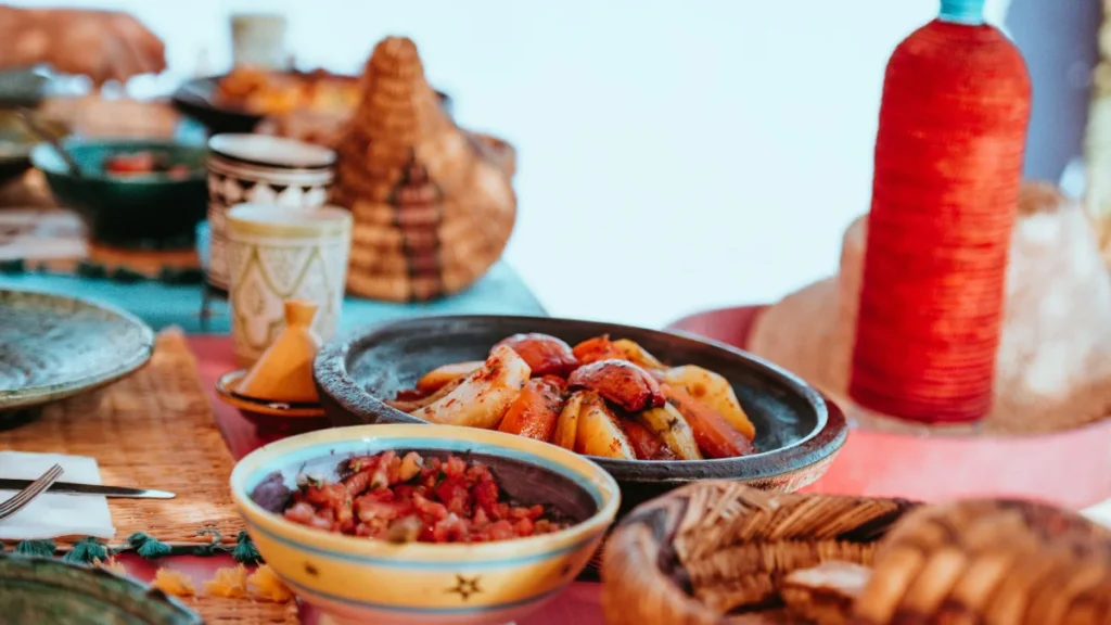 Traditional Moroccan food with tagine and side dishes on a local table