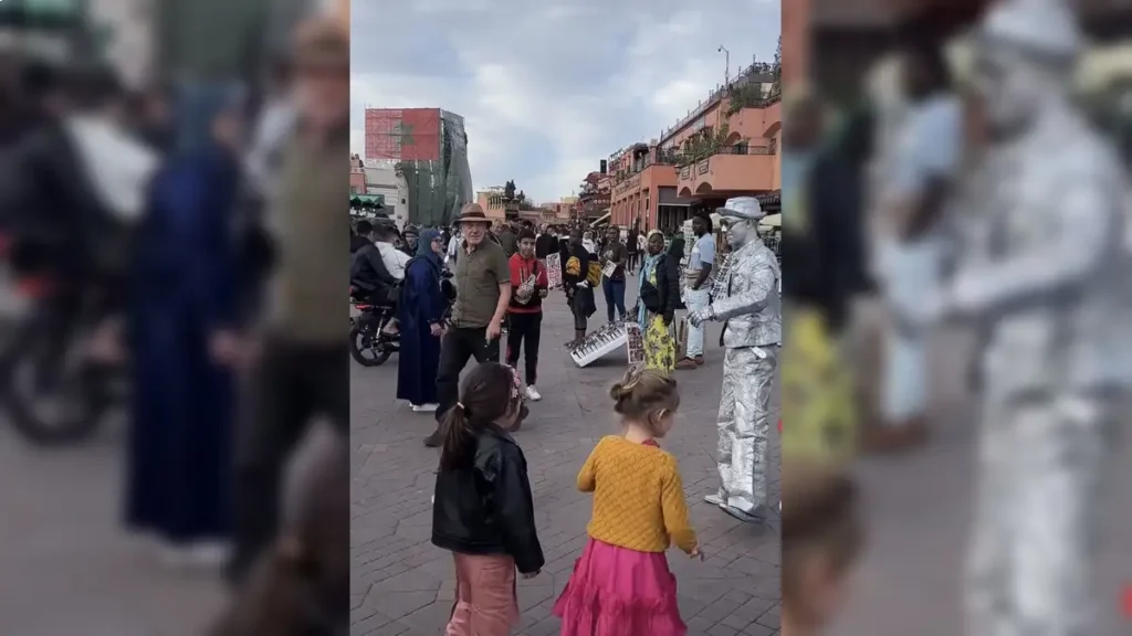 Kids watching a street performer at Jemaa el-Fnaa Square in Marrakech, Morocco