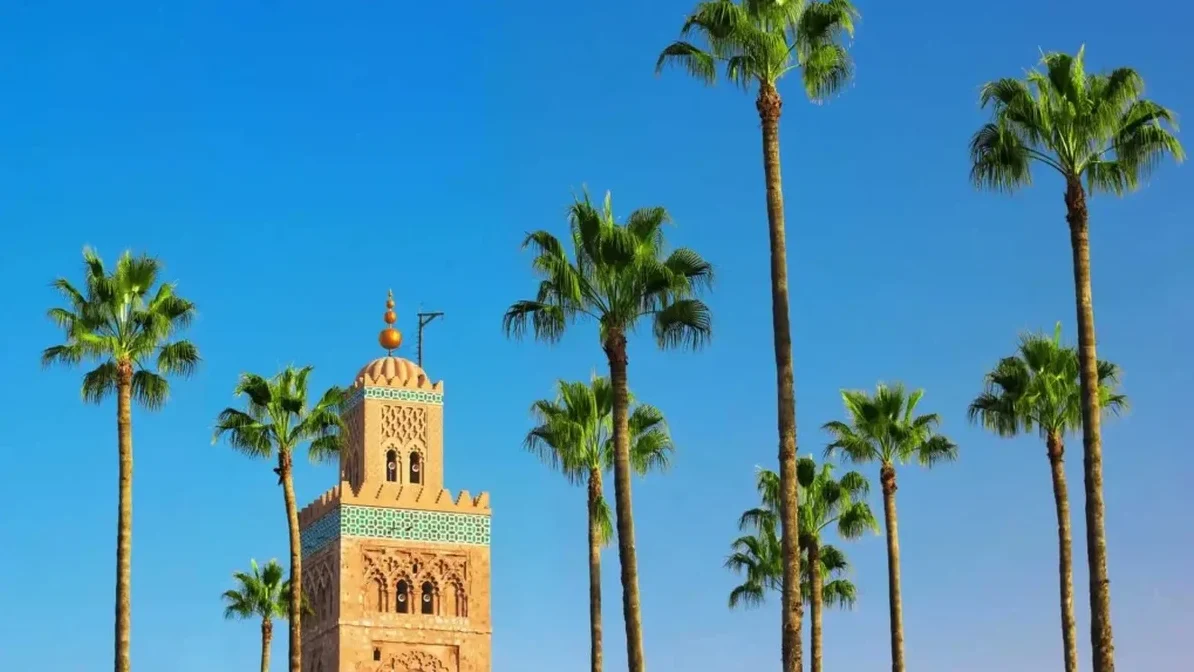 Marrakech Travel Guide – Koutoubia Mosque with palm trees under blue sky