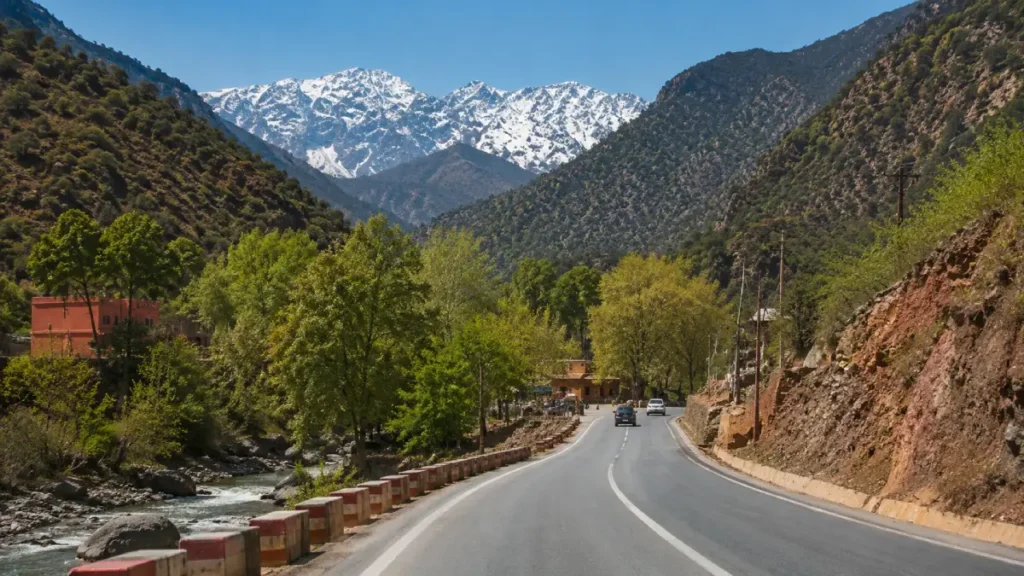 Scenic road from Marrakech to Ourika Valley with High Atlas Mountains, river views, and mountain village landscape