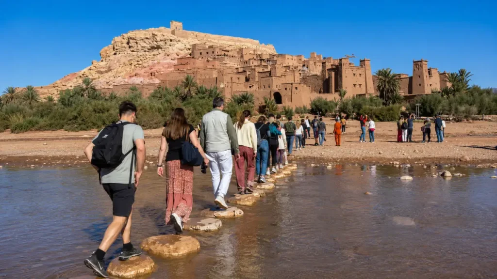 Visitors crossing the river toward Ait Ben Haddou in Morocco