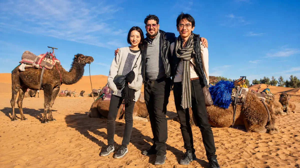Kamal with travelers and camels in the Moroccan Sahara