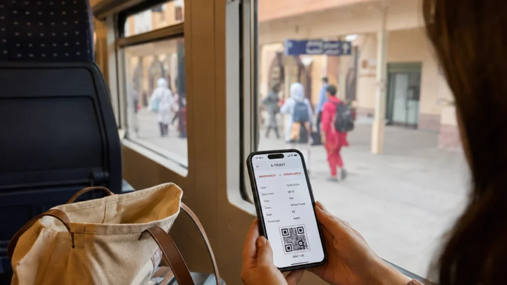 Traveler using a mobile e-ticket while traveling by train in Morocco
