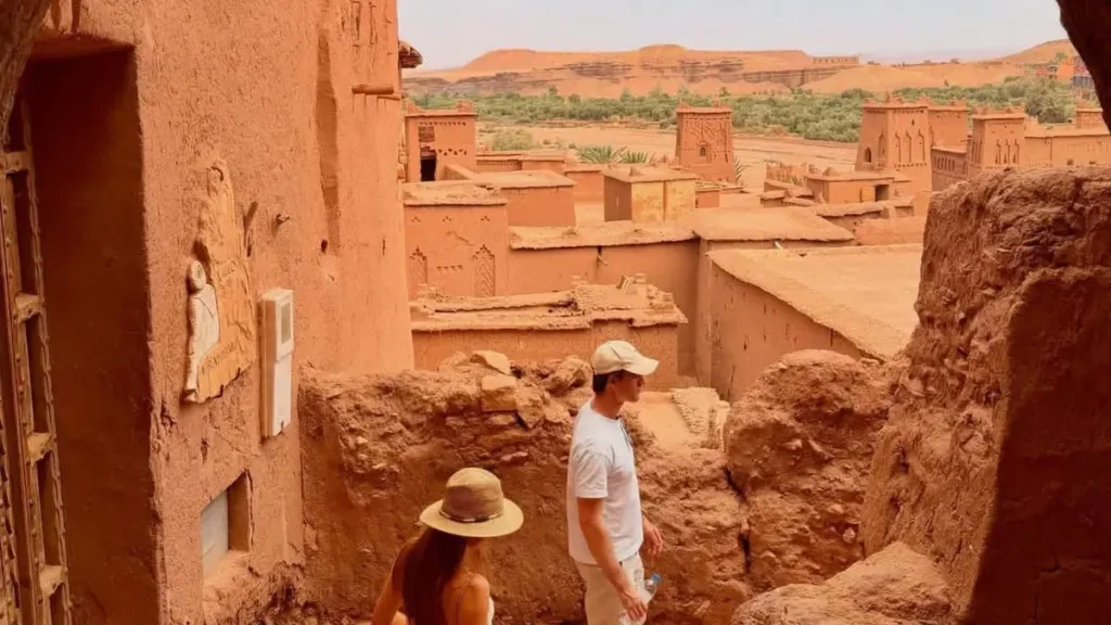 Travelers walking through the earthen alleys of Aït Ben Haddou in Morocco