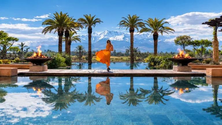 Sunny Marrakech in January with palm trees and snow-covered Atlas Mountains