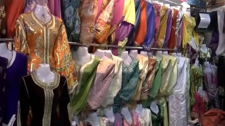Colorful embroidered garments displayed in a shop for travelers buying a kaftan in Marrakech