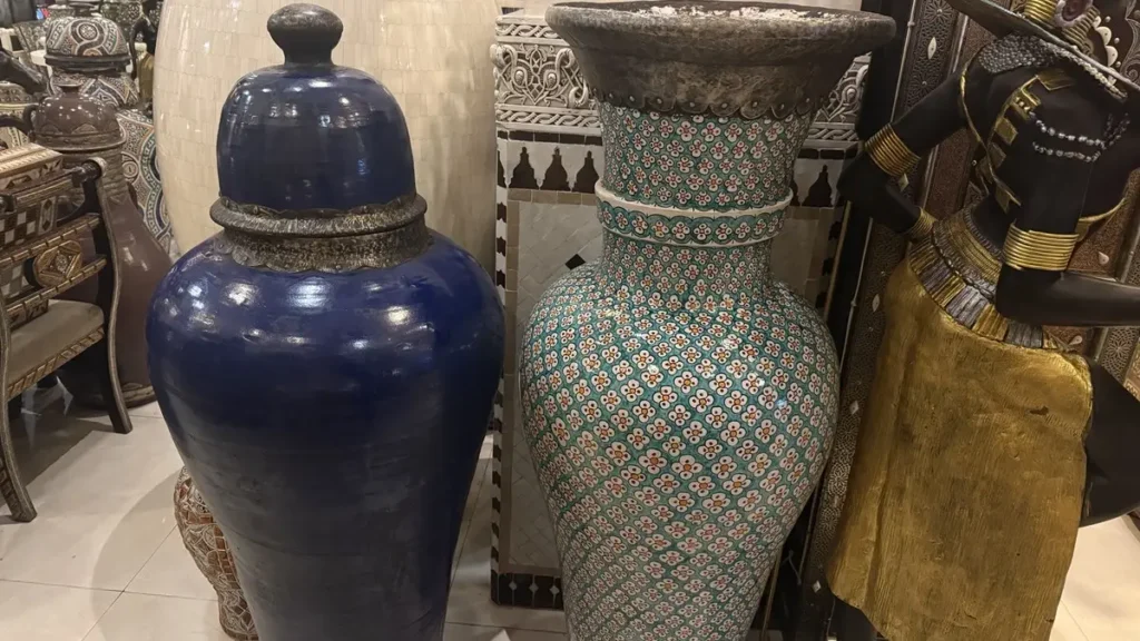 Blue ceramic jar beside a tall patterned decorative vase