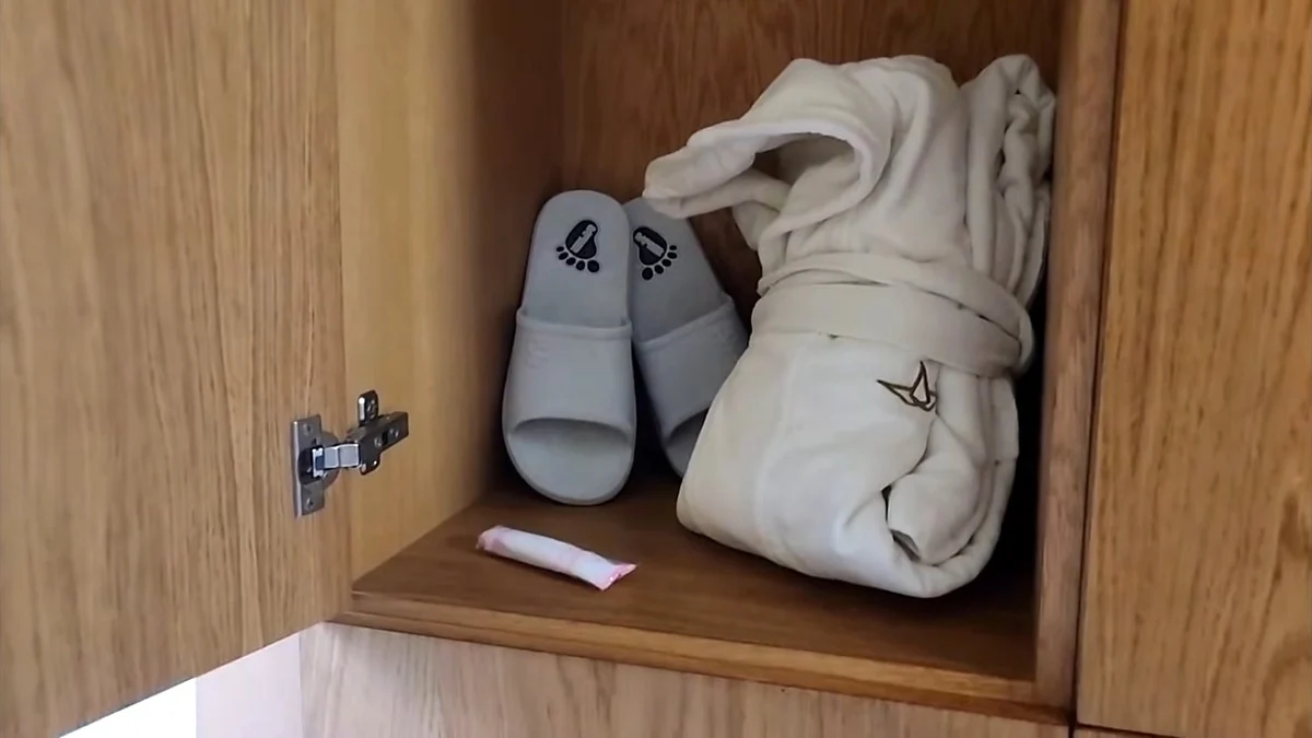 White bathrobe and grey spa slippers inside a wooden locker