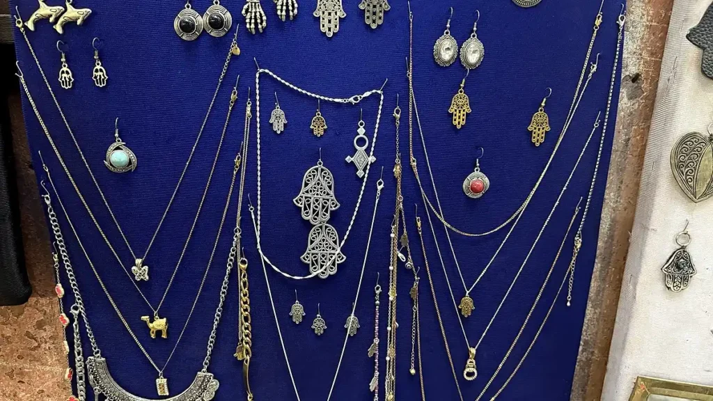 Necklaces and hand-shaped pendants displayed against a blue background
