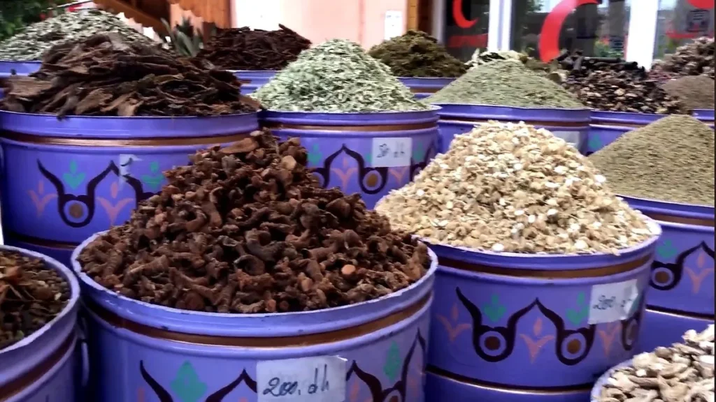 Whole spices and dried herbs displayed in purple patterned containers