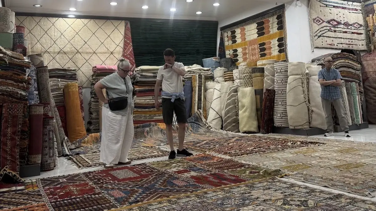 Visitors browsing rugs displayed across a Marrakech showroom