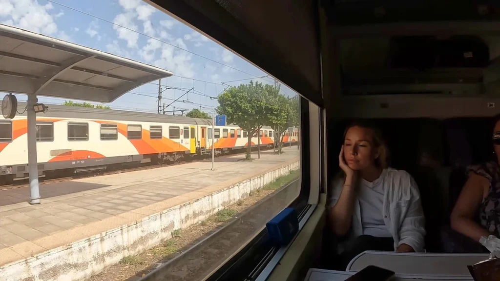 Passenger seated beside a large window inside an ONCF train compartment